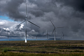 Windmills on agricultural field in Scotland.
