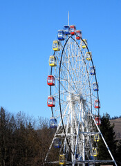 Ferries wheel in the park with red, yellow, blue cabins