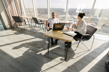 Two office workers working to together 