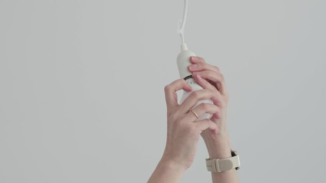 Person uninstalling a light bulb from a ceiling fixture, home maintenance and electrical repair. Home improvement and energy efficient lighting solutions