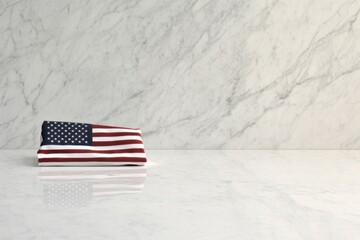 single folded american flag rests atop polished white marble surface with ample bright empty copy space