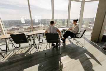 Two office workers working to together 