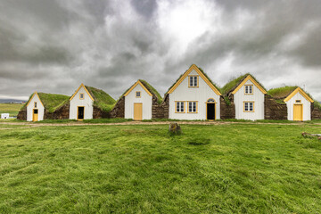Obraz premium Row of historic white and yellow icelandic turf houses with grass roofs
