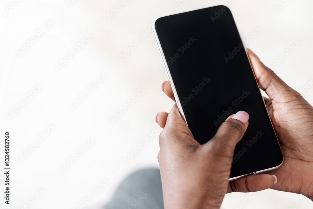 Poster Unrecognizable Black Woman Using Smartphone With Blank Black Screen At Home, Checking New App Or Website, Browsing Internet, Spending Time With Gadget, Mockup Image With Empty Space, Closeup