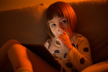 A common childhood habit nose picking. A young child absentmindedly touches their nose, showing a...