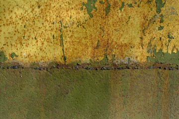 rusty metal surface with peeling paint. Yellow and green