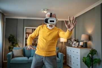 Elderly man explores metaverse with virtual reality headset at home