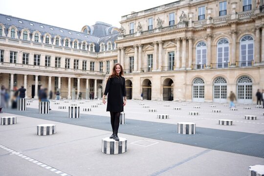 Fototapeta A woman stands confidently amid stunning geometric columns located within a captivating historic setting