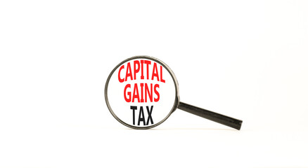 Capital gains tax symbol. Concept words Capital gains tax on beautiful white paper in magnifying glass. Beautiful white paper background. Business and capital gains tax concept. Copy space.