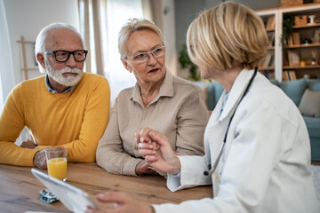 Obraz premium Senior couple discussing medical information with doctor on tablet
