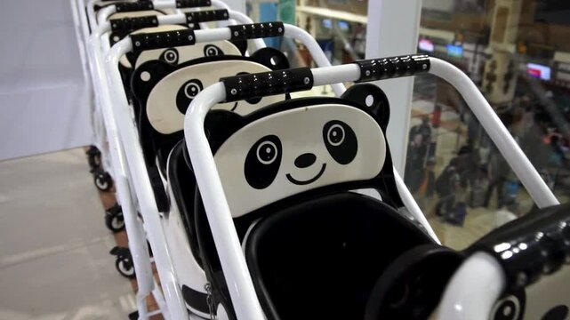 Slow Motion Cinematic of Rows of Panda-Themed Baby Strollers on Display at Airport