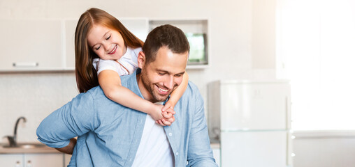 Fototapeta premium Happy Fatherhood. Dad Cooking Holding Little Daughter On Shoulders Enjoying Time Together In Kitchen At Home.