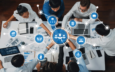 A top-down view of a diverse group of professionals engaged in a collaborative business meeting, featuring digital devices and visual data analysis charts, showcasing teamwork and innovation. Amity
