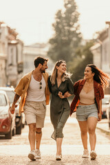 Fototapeta premium Young adults enjoying a carefree walk together on a bright urban day