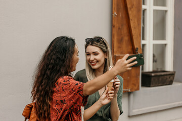 Carefree same-sex diverse couple enjoying a romantic walk, capturing memories with a selfie