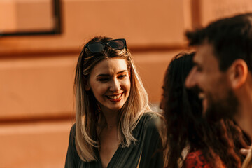 Young adults enjoying a carefree urban walk, sharing smiles and good vibes in the sunshine