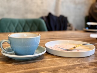 Dirty used dishes. Enjoying a serene coffee moment, with a beautifully crafted cup and a delicious dessert on a rustic wooden table. Close-up