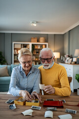 Senior couple watching old photo albums at home