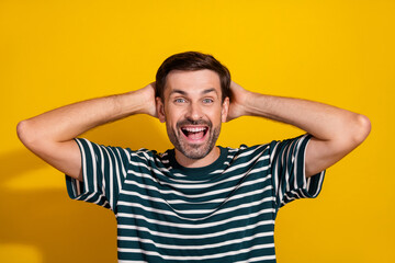 Young bearded man smiling and posing cheerfully against a vibrant yellow background