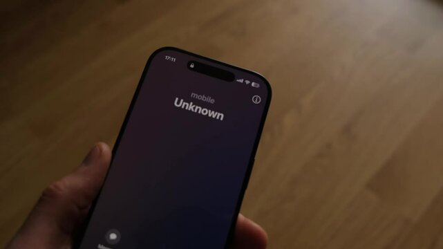 Fraud or fraudulent schemes. Close-up of a male hand holding a phone with an unexpected incoming call from an unknown