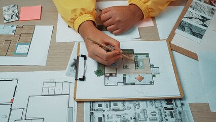 A designer workspace showcasing detailed sketches and colorful notes surrounding a clipboard,...