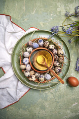 Easter table decor painted eggs on a green plate on a green background, top view