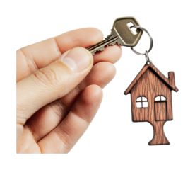Close-up of hand holding key with wooden house keychain, cut out