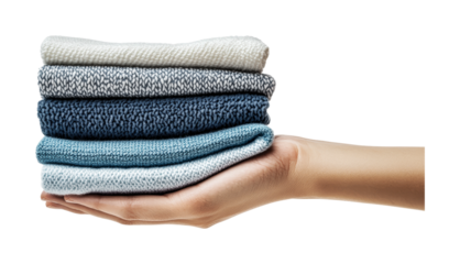 Female hand holding stack of folded knit sweaters in various colors, cut out