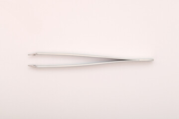 Top view extreme macro photography of white metal tweezers isolated on white background