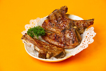 Grilled Lamb Rack or Lamb Chops served in plate isolated on orange background side view of hong kong food