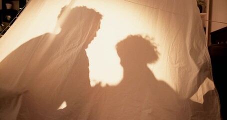 Tent, home and shadow with family, night and games with weekend break, love and happiness. Parent, apartment and child in living room, toys and bonding together with dad, storytelling and silhouette