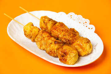 Roasted Tofu skewers served in plate isolated on orange background side view of hong kong food