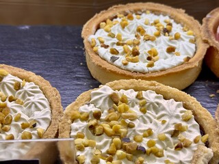 Indulgent and Delicious Mini Nut Tarts, Perfectly Topped with Whipped Cream and Crunchy Toppings....