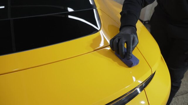 Detailing ceramic polishing at the car service 4k video. Process of applying a ceramic coating to the sports car surface for protection during detailing session at the service.