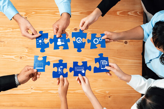 A diverse group of individuals collaborates by connecting puzzle pieces, symbolizing teamwork and the integration of innovative solutions for business challenges. Amity