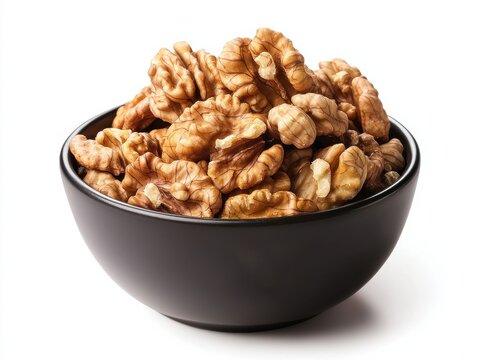 Naklejki Fresh walnut halves in a black ceramic bowl on a clean background