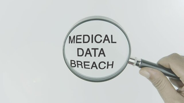 Medical Data Breach text or word highlighted by a magnifying glass in a hand on a white background, symbolizing unauthorized access to sensitive health information, highlighting the need for robust cy