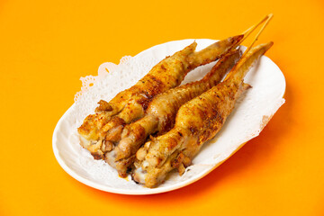 Grilled Chicken Wings on Skewers served in plate isolated on orange background side view of hong kong food