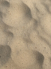 Beige beach sand background with natural pattern. Natural texture, space for text