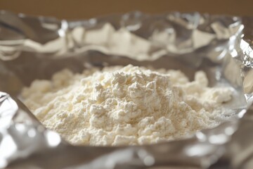 White powder resembling drugs is poured into aluminum foil on a plate, evoking themes of addiction, substance abuse, and illegal activities