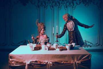Elegant couple in baroque-themed attire dining under neon glow in lavish interior