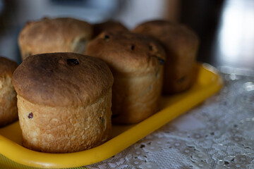 Freshly baked Easter cakes are cooling on a yellow tray on the table