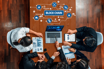 A diverse group of professionals engage in an insightful meeting surrounding blockchain technology, discussing data security and strategic initiatives with digital tools. Amity