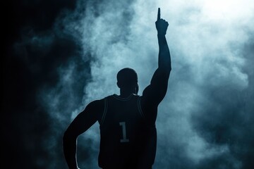 Silhouette of a basketball player celebrating with arms raised and a finger pointed in the air, against a dark background with smoke and mist Generative AI