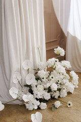 Close up part of wedding party photo booth wall zone decorated with white flowers