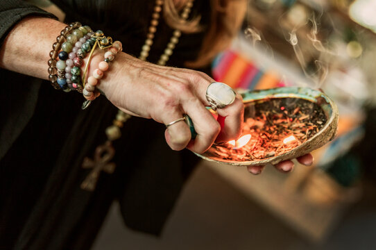 Closeup of a woman lighting sage
