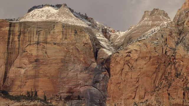 Near the Streaked Wall in Zion NP Ut. USA an ephemeral waterfall pours over the edge of a towering cliff towards the canyon below and gets caught by the wind which whips the water back up into the air