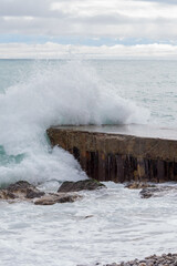 The ocean is rough and the waves are crashing against the rocks