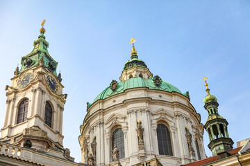 A large white building Prague Czech Republic with a green dome and two clocks on the front
