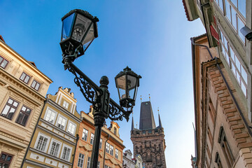 A street scene in Prague Czech Republic with a tall building in the background and two street lamps
